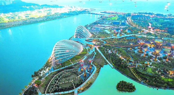 A wide perspective view of ships moored and botanical garden from the roof top of Marina Bay Sand Hotel in Singapore