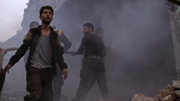 Members of the Syrian civil defence search for survivors in the aftermath of an air strike in the rebel-held town of Harem in the northwestern Idlib province on March 22, 2018. / AFP PHOTO / Aaref WATAD