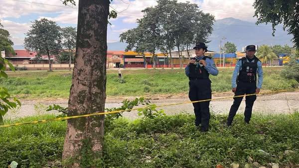 Dos agentes resguardan la escena del crimen.