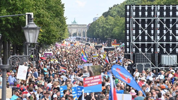Participants gather on the 17. Juni avenue in Berlin at the end of a demonstration called by far-right and COVID-19 deniers to protest against restrictions related to the new coronavirus pandemic, on August 29, 2020. - At the start of August, a similar 'anti-corona' march in Berlin took place with 20,000 protesters, a mixture of the hard left and right, anti-vaccination campaigners, conspiracy theorists and self-described 'free thinkers'. Police broke up the protest early after participants repeatedly flouted Covid-19 safety regulations. (Photo by John MACDOUGALL / AFP)