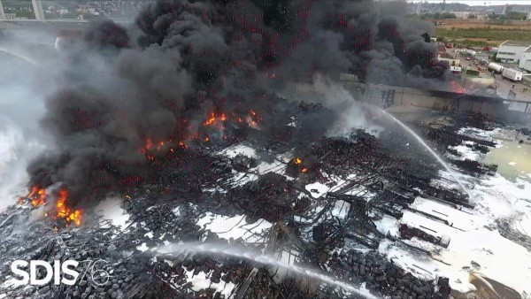 TOPSHOT - This handout video grab taken from footage released by Service Departemental d'incendie et des sec (SDIS) on September 27, 2019, shows an aerial view of firefighters at the scene of a blaze at a Lubrizol factory in Rouen, north-western France. - Firefighters have extinguished a huge blaze that broke out at a chemical factory in northern France and forced authorities to close schools and warn of pollution risks for the Seine river, local authorities said on September 27, 2019. The fire erupted early morning at a storage facility near the city of Rouen owned by Lubrizol, a manufacturer of industrial lubricants and fuel additives which is owned by the billionaire American investor Warren Buffett. (Photo by HO / SDIS / AFP)