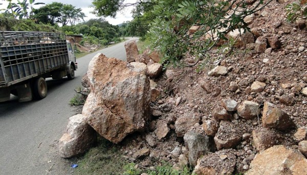 Conductores tienen que maniobrar para no chocar con las rocas que cubren la carretera