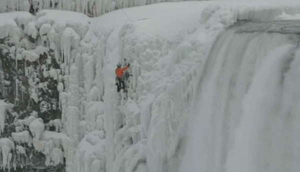 Un hombre escala las congeladas cataratas del Niágara