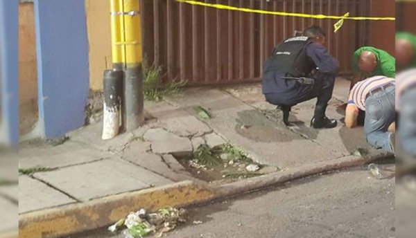 Un agente de la Policía y otras dos personas lamentan la muerte de la mujer policía.