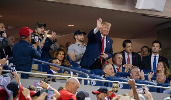 (FILES) In this file photo taken on October 27, 2019 US President Donald Trump (C) waves as US First Lady Melania Trump looks on as they watch Game 5 of the World Series between the Washington Nationals and Houston Astros at Nationals Park in Washington, DC. - The Washington Nationals will attend a White House reception on Monday, just over a week after the baseball team's fans booed President Donald Trump during his World Series appearance at Nationals Park. (Photo by TASOS KATOPODIS / AFP)