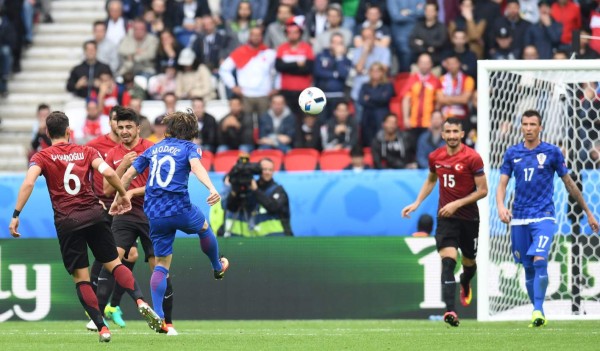 Forward of the Croatian national football team Mario Mandzukic gives an autograph on a local police helmet at the Zagreb International Airport from their open-roof coach during a welcome ceremony on July 16, 2018 in Zagreb. / AFP PHOTO / ATTILA KISBENEDEK