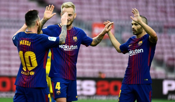 Barcelona's Argentinian forward Lionel Messi (L) celebrates with Barcelona's Croatian midfielder Ivan Rakitic and Barcelona's Spanish midfielder Andres Iniesta after scoring a goal during the Spanish league football match FC Barcelona vs UD Las Palmas at the Camp Nou stadium in Barcelona on October 1, 2017.Barcelona's La Liga match against Las Palmas was played behind closed doors after the Spanish league refused to postpone the match. At least 91 people have been injured in clashes between police and activists in Catalonia over an independence referendum for the region deemed illegal by the Spanish government. / AFP PHOTO / JOSE JORDAN