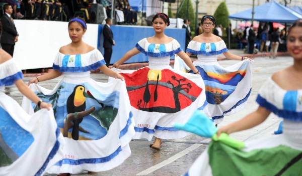 GU4006. CIUDAD DE GUATEMALA (GUATEMALA), 15/09/2016.- Estudiantes con vestidos adornados con estampas de paisajes de Guatemala participan en un desfile por el 195 aniversario de la independencia de Guatemala hoy, jueves 15 de septiembre de 2016, frente al Palacio Nacional de Guatemala en Ciudad de Guatemala (Guatemala). Con el eco de las marchas militares, a ritmo de platillos y tambores, resonó hoy de nuevo en las calles abarrotadas del centro histórico de Guatemala para celebrar con orgullo la independencia el 195 aniversario de la independencia del país centroamericano. EFE/Esteban Biba