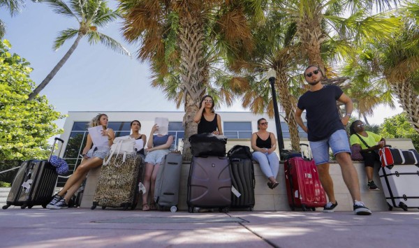 ELX07 MIAMI (ESTADOS UNIDOS) 07/09/2017.- Un grupo de turistas esperan a ser evacuados ante la llegada del huracán Irma a las costas del estado de Florida, en Miami (Estados Unidos) hoy, 7 de septiembre de 2017. Según un probable patrón de trayectoria, el ojo de Irma se situará cerca de el centro de Bahamas el viernes, para cernirse el sábado sobre el sur de la península de Florida. EFE/Erik S. Lesser