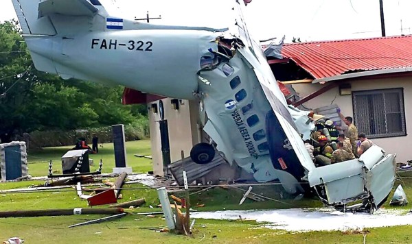 Handout picture released by the firefighters showing their personnel and soldiers working to extract from the wreckage the crewmembrs of a Honduran Air Force Let-410 twin-engine transport aircraft that crashed on a house at the U.S. military base of Palmerola in Comayagua, 70 km north of Tegucigalpa on August 16, 2017 during a test flight.The pilot of the airplane died and the co-pilot was injured. / AFP PHOTO / Honduran Firefighters / HO / RESTRICTED TO EDITORIAL USE - MANDATORY CREDIT 'AFP PHOTO /HONDURAN FIREFIGHTERS' - NO MARKETING NO ADVERTISING CAMPAIGNS - DISTRIBUTED AS A SERVICE TO CLIENTS