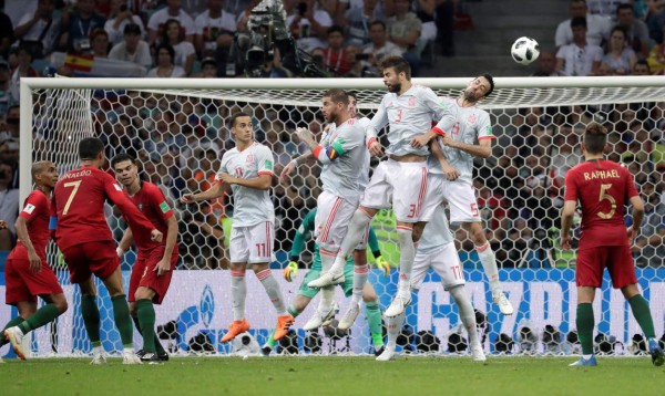 MUN04-235. SOCHI (RUSIA), 15/06/2018.- El delantero portugués Cristiano Ronaldo (i) marca de falta directa el 3-3 durante el partido Portugal-España, del Grupo B del Mundial de Fútbol de Rusia 2018, en el Fisht de Sochi, Rusia, hoy 15 de junio de 2018 (RUSSIA SOCCER FIFA WORLD CUP, Portugal, Spain, Sochi). EFE/Sebastião Moreira [ATENCIÓN EDITORES: Sólo Uso editorial. Prohibido su uso en referencia con entidad comercial alguna. Prohibido su uso en alertas, descargas o mensajería multimedia en móviles. Las imágenes deberán aparecer como fotografías congeladas y no podrán emular la acción del juego mediante secuencias o fotomontajes. Ninguna imagen publicada podrá ser alterada, mediante texto o imagen superpuesta, en el caso de que (a) intencionalmente oculte o elimine el logotipo de un patrocinador o (b) añada y/o cubra la identificación comercial de terceras partes que no esté oficialmente asociada con la Copa Mundial de la FIFA.]