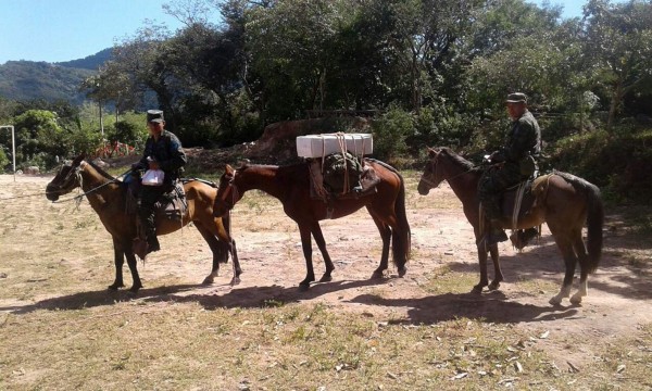 This handout photo released by the national interagency security force, FUSINA, shows Honduran army soldiers setting out from Tegucigalpa to carry election material on horseback and mules to polling stations in remote villages on November 25, 2017, the day before the general elections. President Juan Orlando Hernandez is poll favorite for Sunday's elections, and expects to be re-elected despite the one-term limit set by the constitution. His conservative National Party contends that a 2015 Supreme Court ruling voided that restriction. But the opposition argues that the court does not have the power to overrule the constitution. / AFP PHOTO / FUSINA / HO / RESTRICTED TO EDITORIAL USE-MANDATORY CREDIT 'AFP PHOTO/FUSINA' NO MARKETING NO ADVERTISING CAMPAIGNS-DISTRIBUTED AS A SERVICE TO CLIENTS-GETTY OUT