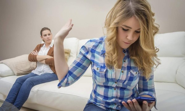 Daughter looking a phone and ignoring her mother