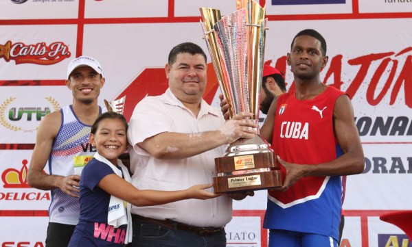 El cubano Richer Pérez en el momento que recibía el trofeo del primer lugar en 21 kilómetros internacional. José Santana derecha- y Didimo Sánchez -izquierda- hicieron el segundo y tercer lugar respectivamente.