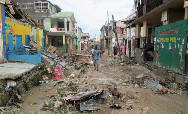 Varias personas circulan por una calle de la localidad de Jeremie, una de las más afectadas por el paso de Matthew. Foto: AFP