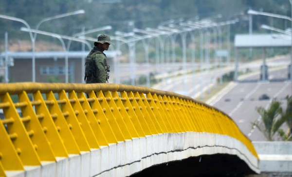 A Venezuelan military officer stands guard as containers block the Tienditas Bridge, which links Tachira, Venezuela, and Cucuta, Colombia, on February 6, 2019. - Venezuelan military officers blocked a bridge on the border with Colombia ahead of an anticipated humanitarian aid shipment, as opposition leader Juan Guaido stepped up his challenge to President Nicolas Maduro's authority. (Photo by Raul Arboleda / AFP)