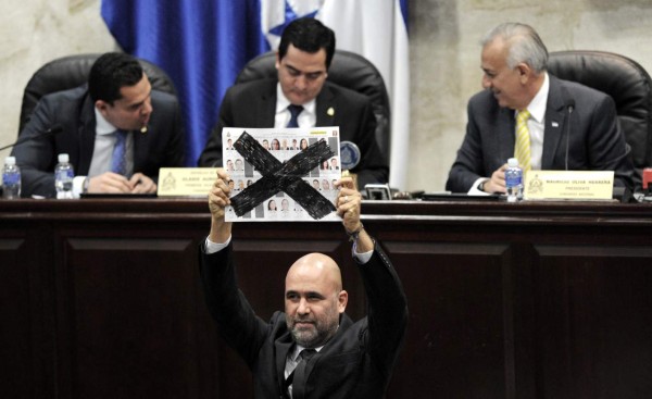 An opposition deputy shows a crossed out ballot as he refuses to vote for the candidates to the Supreme Court of Justice at the Honduran Congress in Tegucigalpa on January 28, 2016. Eight of 15 magistrates were elected past Thursday, but seven are still to be elected among 37 candidates, since they need at least 86 votes of the 128 deputies. AFP PHOTO/Orlando SIERRA