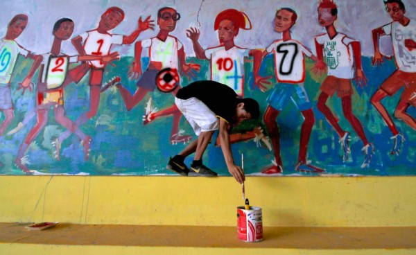 A youngster deported from the US makes a mural at Italian priest Ferdinando Castriotti's foundation in El Paraiso, Honduras, in the border with Nicaragua, on October 20, 2019. - Castriotti trains deportees to facilitate their social insertion. (Photo by STR / AFP)