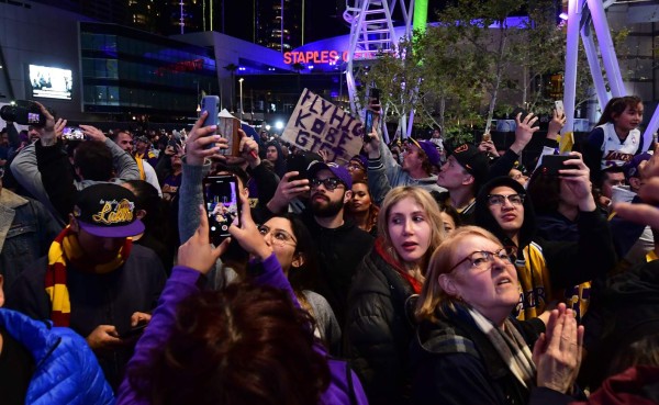 Fans gather to the mourn the death of NBA legend Kobe Bryant, who was killed along with his daughter and seven others in a helicopter crash on January 26, at LA Live plaza in front of Staples Center in Los Angeles on January 27, 2020. - Federal investigators sifted through the wreckage of the helicopter crash that killed basketball legend Kobe Bryant and eight other people, hoping to find clues to what caused the accident that stunned the world. (Photo by Frederic J. BROWN / AFP)