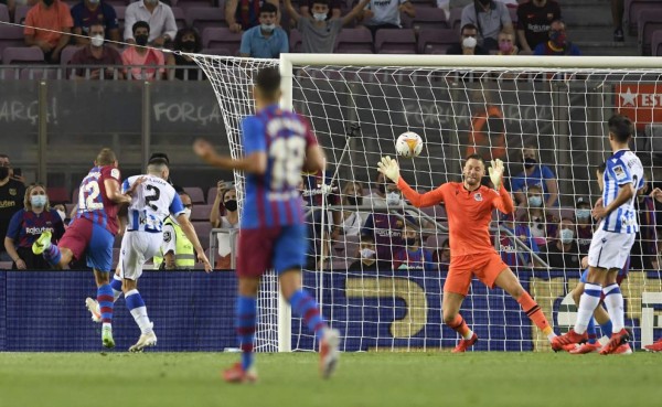 Barcelona's Danish forward Martin Braithwaite (L) heads the ball to score during the Spanish League football match between Barcelona and Real Sociedad at the Camp Nou stadium in Barcelona on August 15, 2021. (Photo by Josep LAGO / AFP)