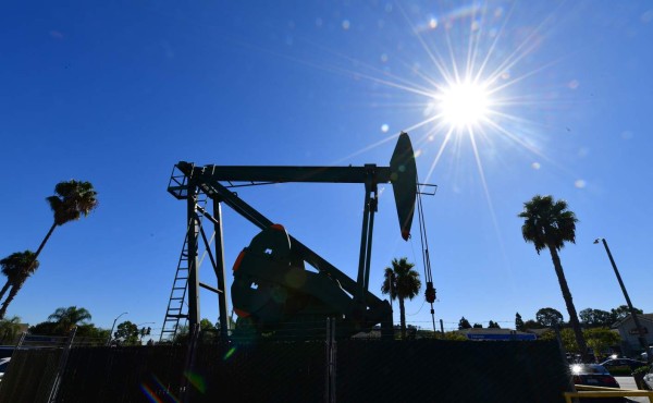 (FILES) In this file photo taken on October 21, 2019 a pumpjack from California-based energy company Signal Hill Petroleum is seen in front of the landmark Curley's Cafe, one of two pumpjacks in the Diner's parking lot which has been churning out oil from the ground below since 1921 in Signal Hill, California. - Oil prices soared more than four percent on January 3, 2020 and equities reversed early gains following news that the US had killed a top Iranian general, fanning fresh fears of a conflict in the crude-rich region. (Photo by Frederic J. BROWN / AFP)