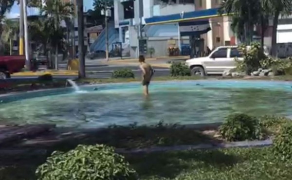 En el video se observa al hombre bañando mientras los vehículos detienen su marcha.