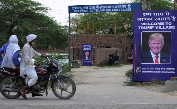 Un cartel con la imagen del Presidente de los Estados Unidos Donald Trump se establece en la entrada del pueblo. AFP