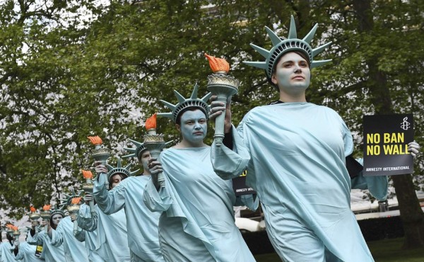 ARA10 LONDRES (REINO UNIDO) 27/04/2017.- Activistas de Amnistia Internacional, con trajes de la Estatua de la Libertad, protestan frente a la Embajada de EE.UU. en Londres (Reino Unido) hoy, 27 de abril de 2017, al cumplirse los primeros 100 días en el gobierno del presidente estadounidense, Donald Trump, para resaltar las supuestas violaciones de los derechos humanos cometidos durante su mandato. EFE/Andy Rain