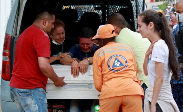 El recluso Ricardo Alegría llora sobre el ataúd de su hija antes de su funeral. EFE
