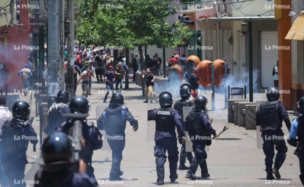 Policía antimotines lanzaron bombas lacrimógenas para dispersar a los encapuchados.