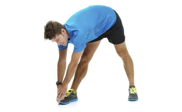 Parado derecho con las piernas entreabiertas, doble lentamente la espalda y coloque las manos en el pie. Haga 10 repeticiones de cada lado.