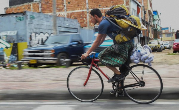 Colombian Jahn Fredy Duque rides his bike to the spot where he will perform on the streets in Bogota, Colombia, dressed up as superhero 'Spiderman', on April 24, 2017. Duque hangs a white cloth 26 meters long - his 'cobweb - from a bridge near the international center of Bogota, where he performs in the street for a livelihood. / AFP PHOTO / RAUL ARBOLEDA