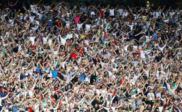 Iranian women cheer during the World Cup Qatar 2022 Group C qualification football match between Iran and Cambodia at the Azadi stadium in the capital Tehran on October 10, 2019. - The Islamic republic has barred female spectators from football and other stadiums for around 40 years, with clerics arguing they must be shielded from the masculine atmosphere and sight of semi-clad men. Women fans are attending the football match freely for the first time in decades, after FIFA threatened to suspend the country over its controversial male-only policy. (Photo by ATTA KENARE / AFP)