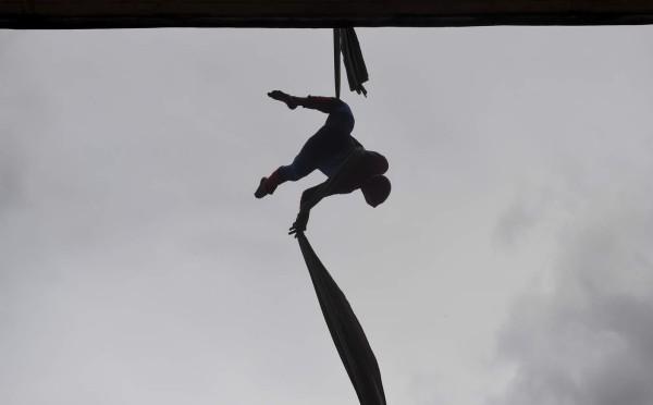 Colombian Jahn Fredy Duque, dressed as superhero 'Spiderman', performs on the streets in Bogota, Colombia on April 24, 2017. Duque hangs a white cloth 26 meters long - his 'cobweb - from a bridge near the international center of Bogota, where he performs in the street for a livelihood. / AFP PHOTO / RAUL ARBOLEDA