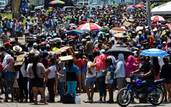Local residents line up to receive food supplies in Manta, Ecuador on April 20, 2016. The death toll from Ecuador's earthquake was set to rise sharply after authorities warned that 1,700 people were still missing and anger gripped families of victims trapped in the rubble. A 6.1-magnitude earthquake struck off the coast of Ecuador Wednesday, sowing new panic four days after a more powerful quake killed more than 525 people, with hundreds still missing. / AFP PHOTO / LUIS ACOSTA