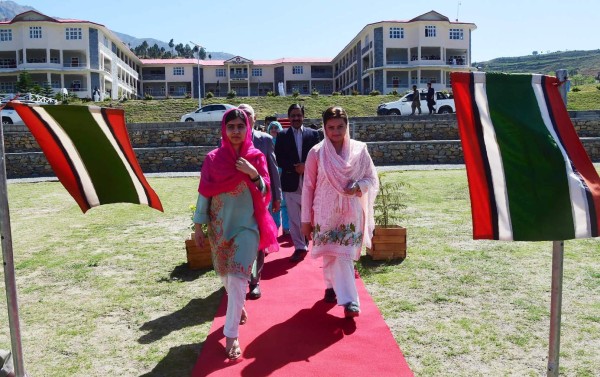 Pakistani activist and Nobel Peace Prize laureate Malala Yousafzai (L), arrives with Pakistani Minister of State for Information and Broadcasting, Maryam Aurangzeb upon her arrival at the all-boys Swat Cadet College Guli Bagh, during her hometown visit, some 15 kilometres outside of Mingora, on March 31, 2018.Malala Yousafzai landed in the Swat valley on March 31 for her first visit back to the once militant-infested Pakistani region where she was shot in the head by the Taliban more than five years ago. / AFP PHOTO / ABDUL MAJEED