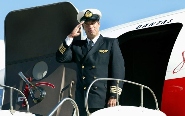 (FILES) A file photo taken on July 12, 2002, shows Hollywood star and Qantas 'Ambassador-at-Large' John Travolta, standing in front of his Boeing 707 at Sydney Airport.Travolta has donated his 'beloved' Boeing 707 plane to an Australian aviation museum and is aiming to be part of the crew to deliver the vintage aircraft down under. Made for Qantas Airways in 1964, Travolta acquired the Boeing 707 long after Australia's national carrier retired the jet. / AFP PHOTO / Greg Wood
