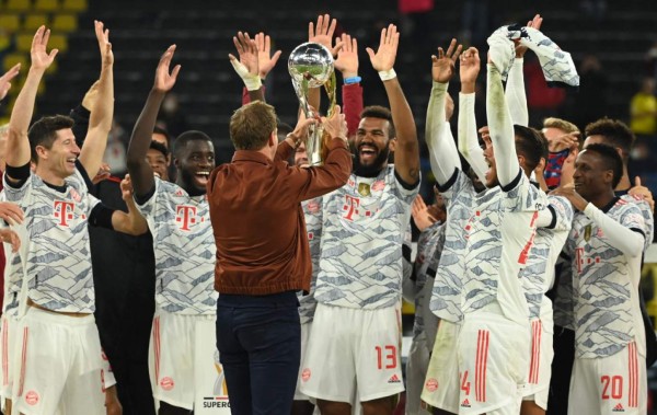 Bayern Munich's German head coach Julian Nagelsmann hands the trophy to Bayern Munich's Cameroonian forward Eric Maxim Choupo-Moting after the German Supercup football match BVB Borussia Dortmund vs FC Bayern Munich in Dortmund, on August 17, 2021. (Photo by Ina Fassbender / AFP) / DFL REGULATIONS PROHIBIT ANY USE OF PHOTOGRAPHS AS IMAGE SEQUENCES AND/OR QUASI-VIDEO