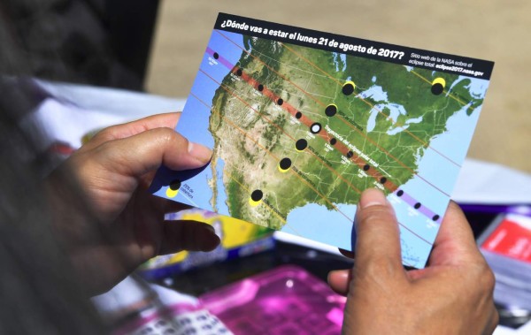 A woman views a map showing the route of the sun crossing the United States during the Solar Eclipse Festival at the California Science Center in Los Angeles, California on August 19, 2017, two days before The Solar Eclipse on Monday August 21. / AFP PHOTO / FREDERIC J. BROWN