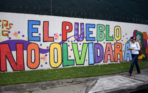 A woman walks by a mural painting outside the headquarters of the UN International Commission Against Impunity, CICIG, to acknowledge its performance against corruption, in Guatemala City on August 31, 2019. - The Cicig's mandate comes to an end next Tuesday after President Jimmy Morales broke his promise to extend it for two more years. (Photo by Johan ORDONEZ / AFP)