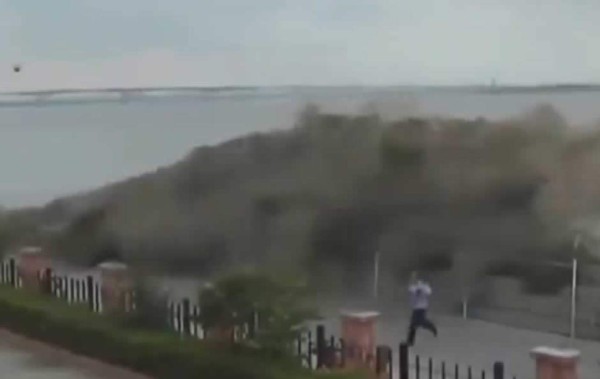 Enorme ola en China arrasa con una zona de paseo y con curiosos