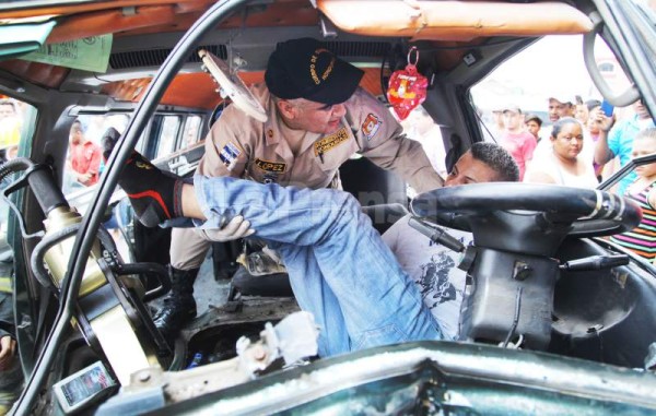 Los bomberos al momento de sacar del rapidito al conductor de la unidad.