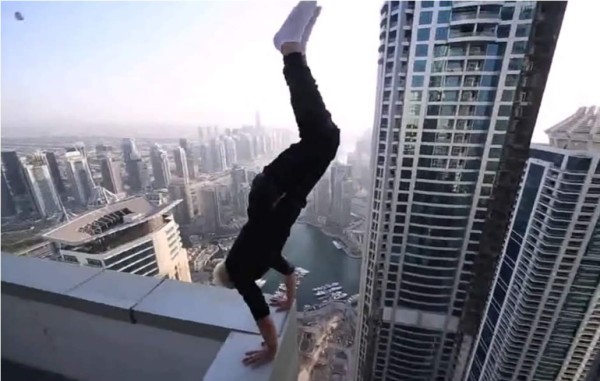 Hombre realiza acrobacias en la cima de un rascacielos