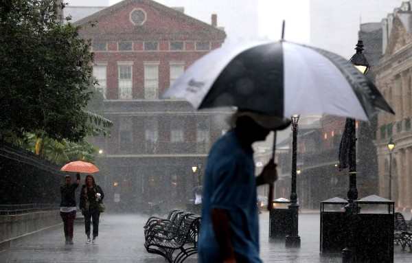 NEW ORLEANS, LA - OCTOBER 07: Tourists run to avoid the rain as strong winds and heavy rain from Hurricane Nate begin to come ashore on October 7, 2017 in New Orleans, Louisiana. Nate is expected to make landfall as a category 2 hurricane near Biloxi, Mississippi later this evening. Sean Gardner/Getty Images/AFP== FOR NEWSPAPERS, INTERNET, TELCOS & TELEVISION USE ONLY ==