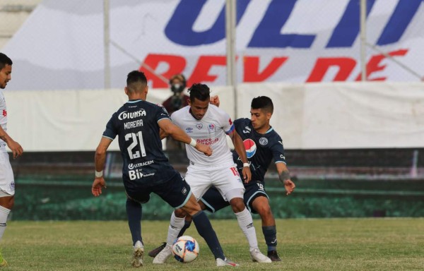 Edwin Rodríguez del Olimpia ante la marca de Gálvaliz y Roberto Moreira del Motagua.