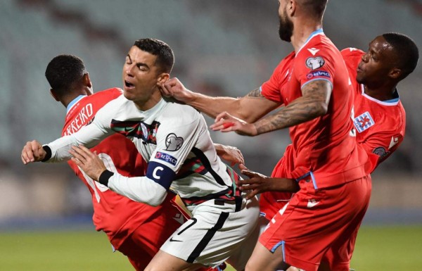 Portugal's forward Cristiano Ronaldo reacts as he is tackled during the FIFA World Cup Qatar 2022 qualification Group A football match between Luxembourg and Portugal at the Josy Barthel Stadium, in Luxembourg City, on March 30, 2021. (Photo by JOHN THYS / AFP)
