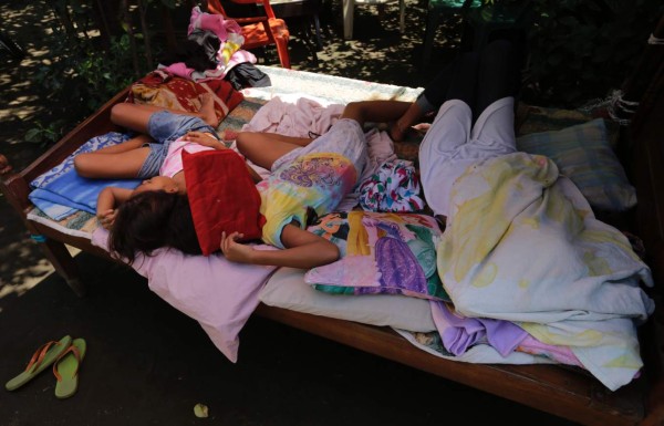 Kids sleep in the backyard of their damaged house after an earthquake in Community Tonala, el Viejo, Chinandega department, some 150km north of Managua on June 10, 2016.A strong 6.1 magnitude earthquake and at least four major aftershocks shook northwestern Nicaragua on Thursday night, triggering panic among residents and damaging some homes, officials said. There were no immediate reports of casualties. / AFP PHOTO / INTI OCON