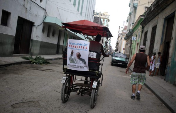 HAB01. LA HABANA (CUBA), 18/09/2015.- Un bicitaxi circula con un cartel con la imagen del papa Francisco en La Habana (Cuba) hoy, viernes 18 de septiembre de 2015, a una día del inicio de la visita del pontífice a la isla. En Cuba todo está listo para recibir mañana a Francisco, el tercer pontífice que visita el país, un viaje cargado de simbolismo por el papel mediador que la diplomacia Vaticana desempeñó en la reconciliación con Estados Unidos, que a su vez levantó hoy más sanciones contra la isla. EFE/Alejandro Ernesto