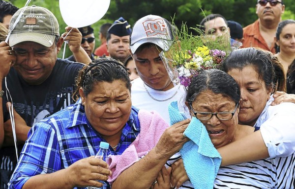 La madre y los hermanos de Marlene Banegas lloran mientras observan el entierro de los restos de la fiscal.