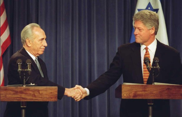 (FILES) This file photo taken on December 11, 1995 shows US President Bill Clinton (R) and Israeli Prime Minister Shimon Peres (L) shaking hands during a joint press conference 11 December at the Old Executive Office Building in Washington.Israeli ex-president and Nobel Peace Prize winner Shimon Peres died on September 28, 2016, his personal doctor told AFP, some two weeks after suffering a major stroke. / AFP PHOTO / PAUL J. RICHARDS